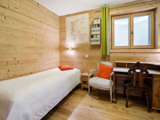 This charming bedroom features warm, natural wood paneling throughout, creating a cozy and inviting atmosphere.