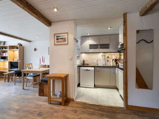 This charming living space features exposed wooden beams on the ceiling, adding rustic character.