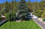 Nestled against a backdrop of lush pine trees, this stunning property offers a serene escape.