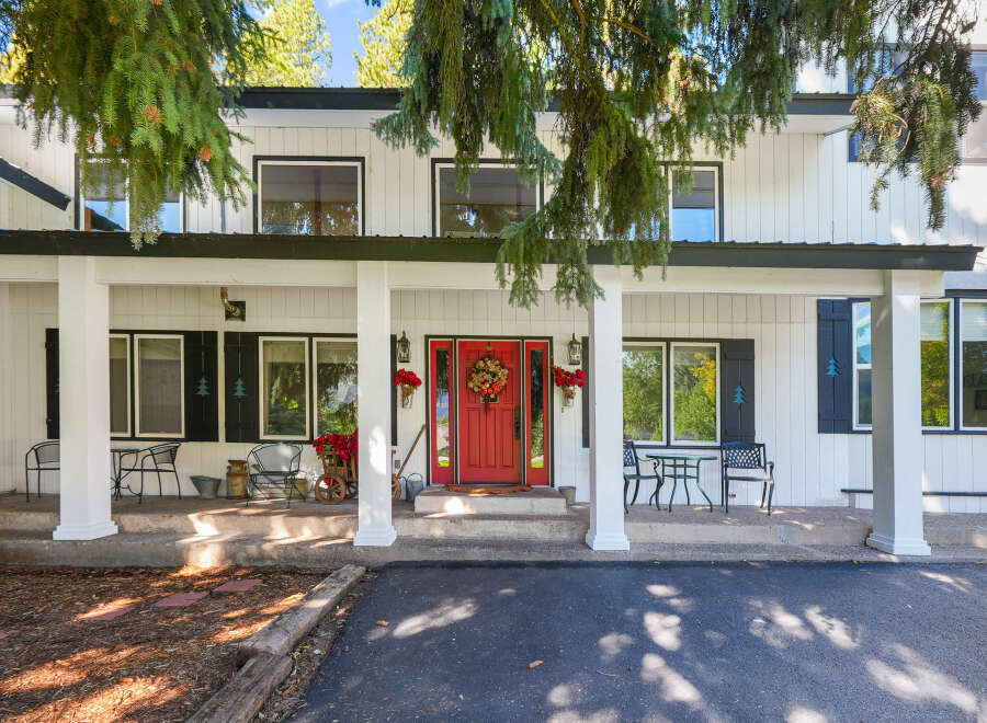 Welcome to this charming home featuring a bright red front door, perfect for greeting guests.