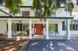 Welcome to this charming home featuring a bright red front door, perfect for greeting guests.