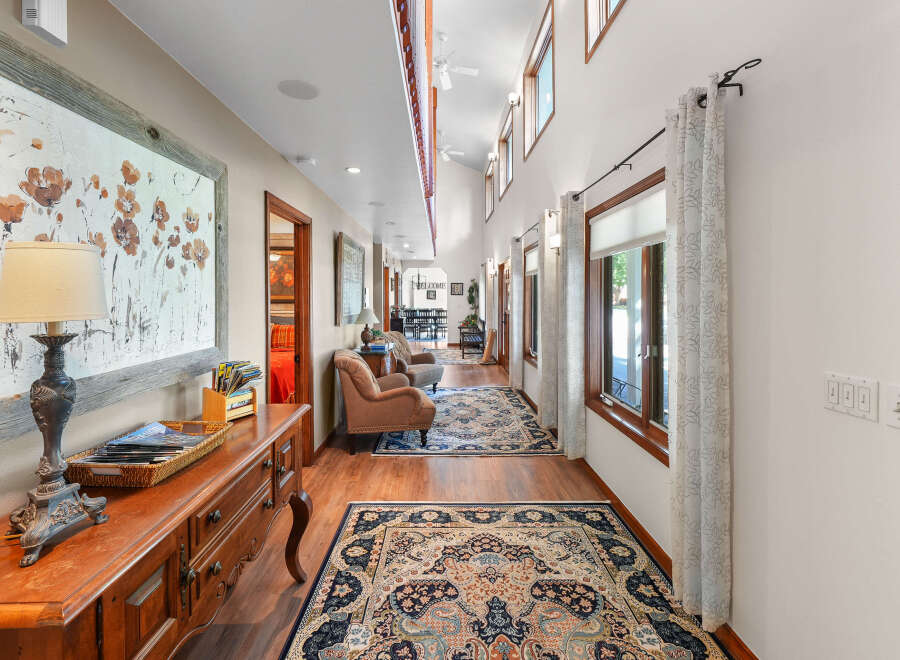 Step into this charming hallway, featuring a warm wooden floor and elegant Persian rugs that guide you through the space.
