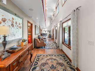 Step into this charming hallway, featuring a warm wooden floor and elegant Persian rugs that guide you through the space.