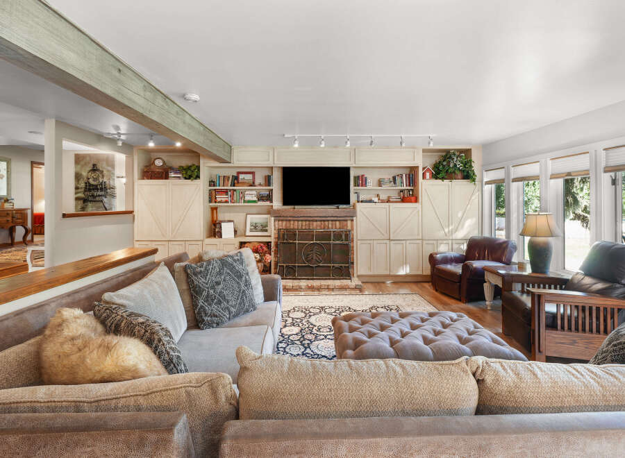 Step into this inviting living room, featuring a large sectional sofa and a plush ottoman perfect for relaxation.