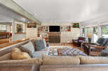 Step into this inviting living room, featuring a large sectional sofa and a plush ottoman perfect for relaxation.