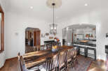 This spacious dining room features a large, rustic wooden table with seating for eight, perfect for family gatherings.