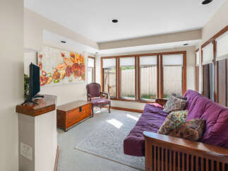 Relax and unwind in this inviting living space, featuring a comfortable purple futon sofa adorned with decorative pillows.