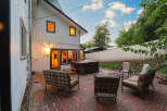 Enjoy outdoor living with this spacious patio featuring comfortable seating and a hot tub, perfect for relaxation and entertaining.