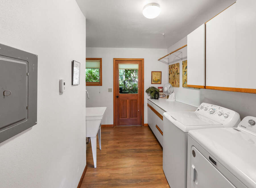 This spacious laundry room features a large utility sink and ample counter space, perfect for folding clothes.