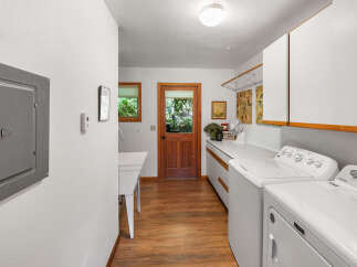 This spacious laundry room features a large utility sink and ample counter space, perfect for folding clothes.