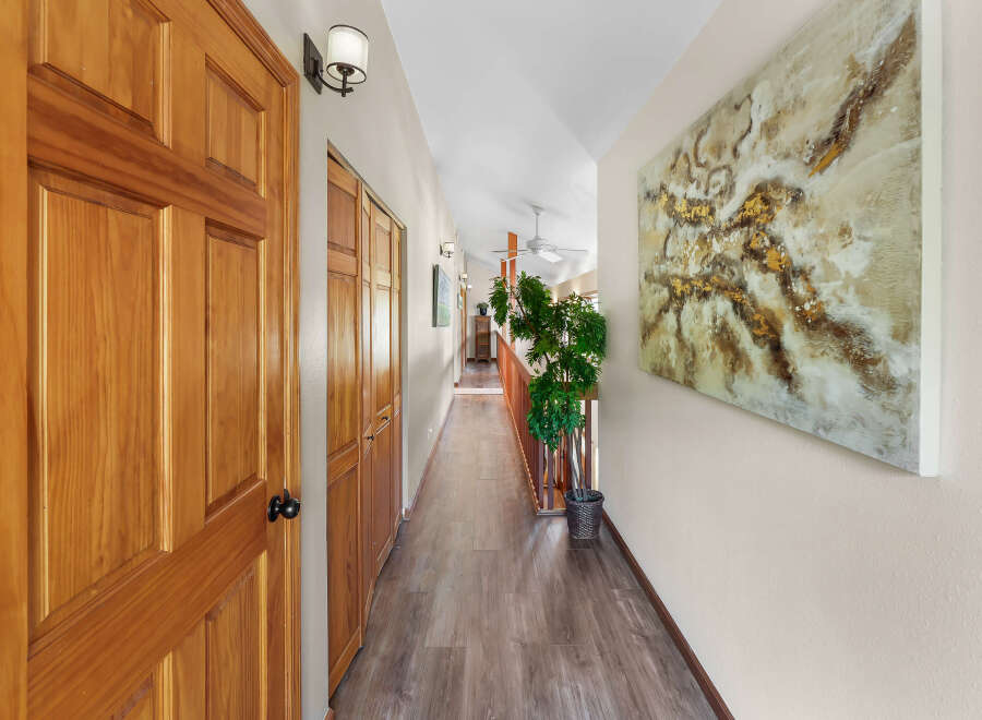 Step into this inviting hallway featuring warm wooden doors and elegant laminate flooring.