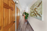 Step into this inviting hallway featuring warm wooden doors and elegant laminate flooring.