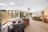 This spacious bedroom suite offers a comfortable living area with a plush sofa and armchairs, perfect for relaxing.