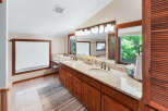 This spacious bathroom boasts a double vanity with granite countertops, offering ample space for morning routines.