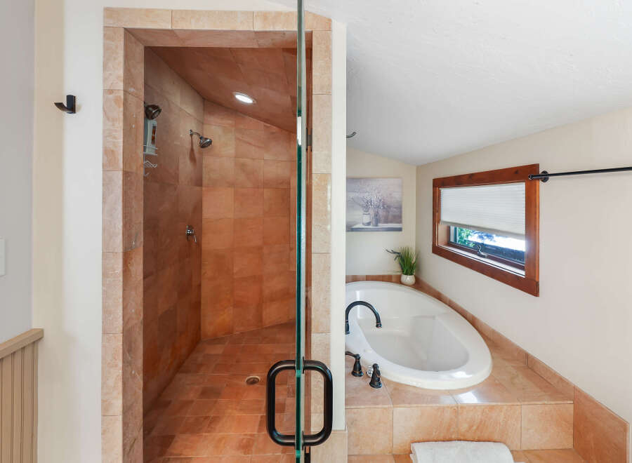 Experience luxury in this stunning bathroom featuring a spacious walk-in shower with elegant tilework and multiple showerheads.