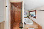 Experience luxury in this stunning bathroom featuring a spacious walk-in shower with elegant tilework and multiple showerheads.