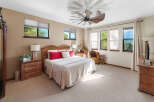Experience ultimate comfort in this spacious bedroom, featuring a luxurious king-size bed adorned with plush red and white pillows.