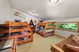 This charming attic bedroom features two sturdy wooden bunk beds with patriotic bedding, perfect for accommodating multiple guests.
