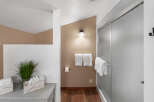This bathroom features a modern shower with frosted glass doors and a sleek chrome handle.