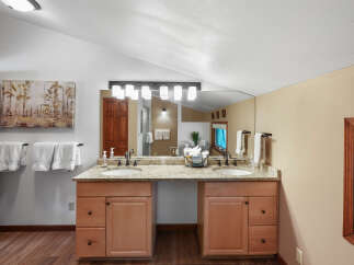 This spacious bathroom features a double vanity with granite countertops and ample storage.