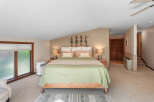 Discover this charming bedroom featuring a comfortable queen-size bed adorned with a light green quilted comforter and accent pillows.