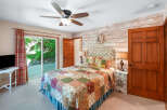 Step into this charming bedroom featuring a cozy queen-size bed adorned with a beautiful patchwork quilt.