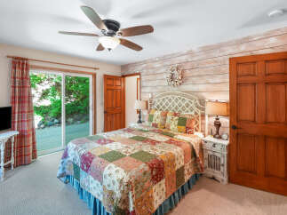 Step into this charming bedroom featuring a cozy queen-size bed adorned with a beautiful patchwork quilt.