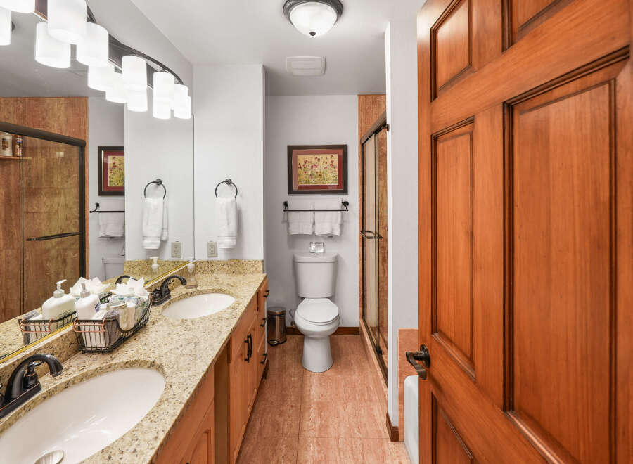 This beautifully appointed bathroom features a double vanity with granite countertops and elegant oil-rubbed bronze fixtures.