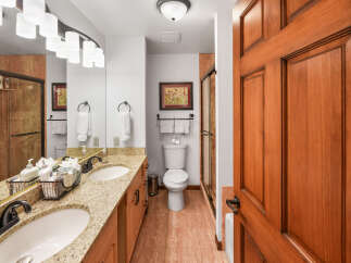 This beautifully appointed bathroom features a double vanity with granite countertops and elegant oil-rubbed bronze fixtures.