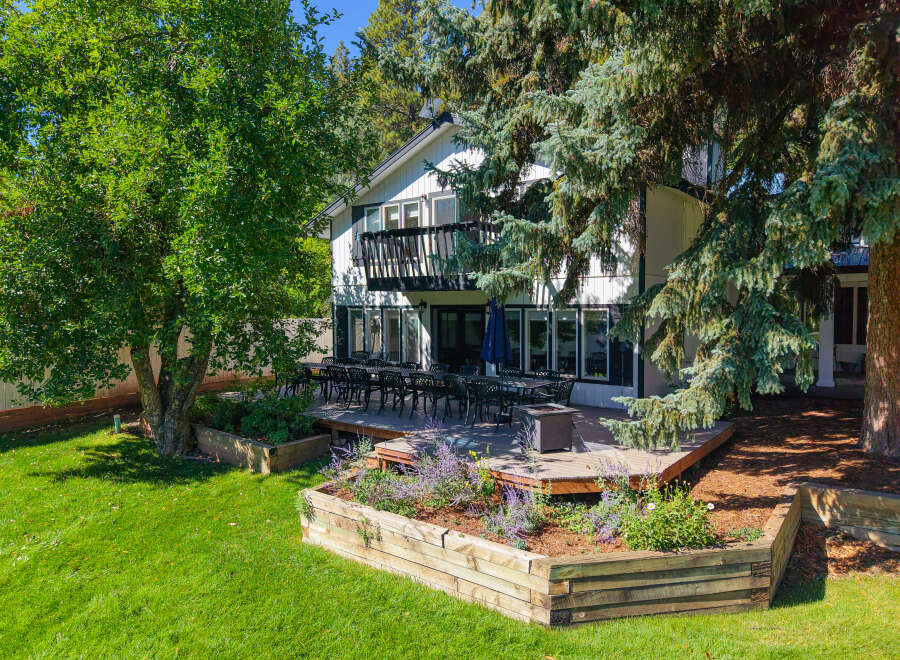 Enjoy outdoor living with this expansive deck, perfect for entertaining, featuring a large dining set and a fire pit.