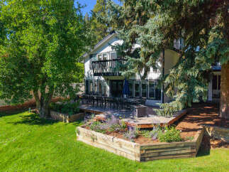 Enjoy outdoor living with this expansive deck, perfect for entertaining, featuring a large dining set and a fire pit.
