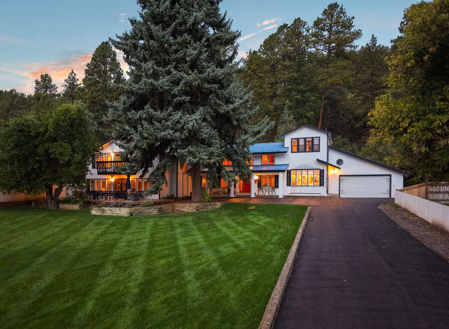 Nestled amidst towering trees, this stunning white home offers a serene retreat.