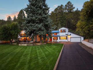 Nestled amidst towering trees, this stunning white home offers a serene retreat.