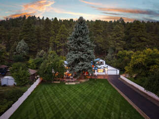 Nestled amidst a lush forest, this stunning property offers a serene retreat with its picturesque setting and inviting architecture.