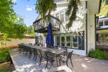 Enjoy outdoor dining and entertaining on this expansive deck, featuring a long table set for many guests and comfortable seating.