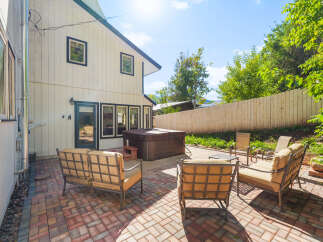 Enjoy outdoor living with this spacious patio featuring comfortable seating and a relaxing hot tub.