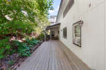 Enjoy outdoor living on this expansive wooden deck, perfect for entertaining or relaxing amidst lush greenery.