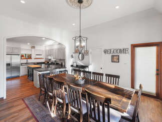 This spacious dining area features a large, rustic wooden table with seating for eight, perfect for family gatherings and entertaining.