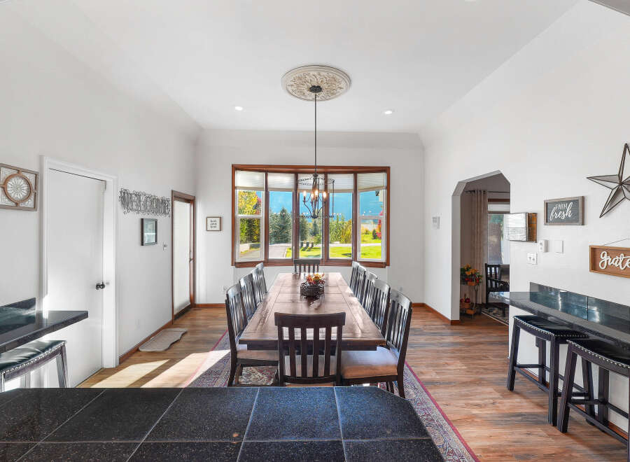 This spacious dining room features a large wooden table with seating for ten, perfect for hosting gatherings.