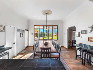 This spacious dining room features a large wooden table with seating for ten, perfect for hosting gatherings.