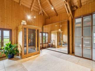 Experience ultimate relaxation in this stunning wooden room featuring a modern glass-enclosed sauna.