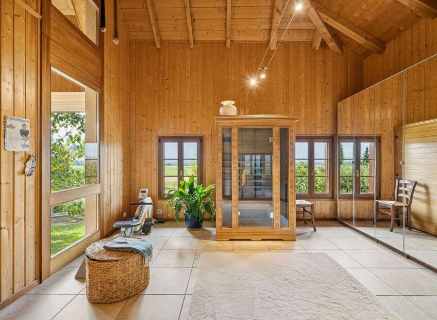 Experience ultimate relaxation and fitness in this beautifully appointed wooden room, featuring a modern infrared sauna and a rowing machine.