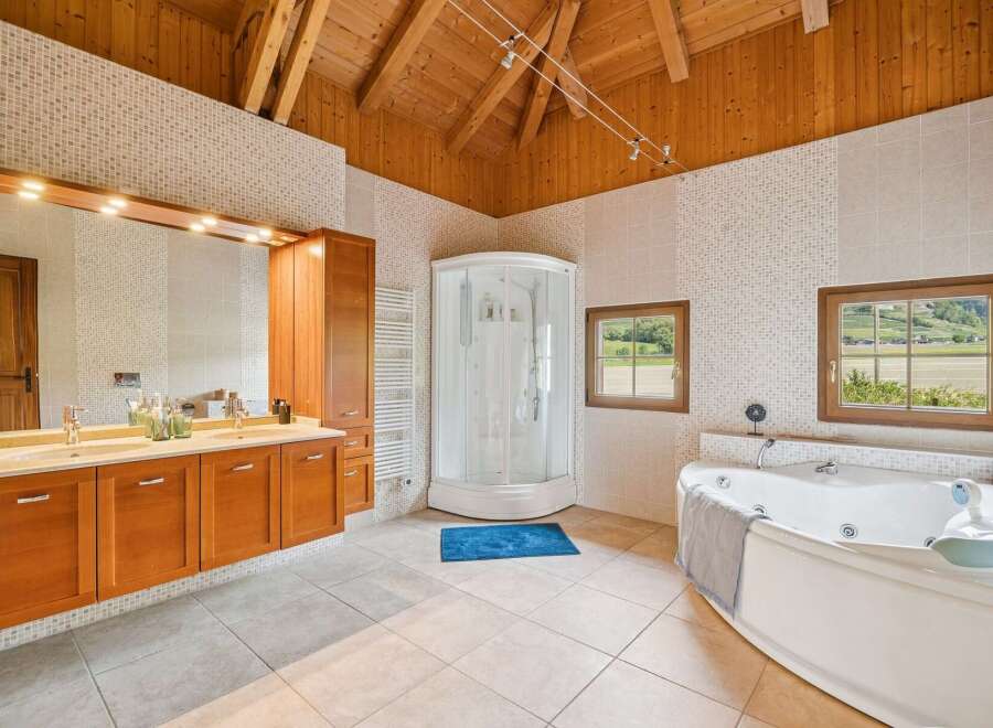Experience luxury in this spacious bathroom featuring a large corner jacuzzi tub and a separate glass-enclosed shower.
