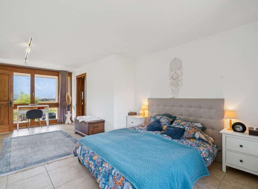 Experience comfort and style in this beautifully appointed bedroom, featuring a plush king-sized bed with a decorative headboard and vibrant floral bedding.