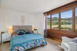 Experience breathtaking views from this charming bedroom, featuring a comfortable bed adorned with vibrant floral bedding and a cozy blue quilt.