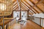 Discover this charming attic space featuring exposed wooden beams and a vaulted ceiling, creating a rustic and warm ambiance.