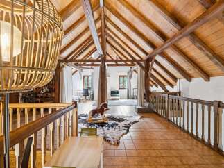Discover this charming attic space featuring exposed wooden beams and a vaulted ceiling, creating a rustic and warm ambiance.