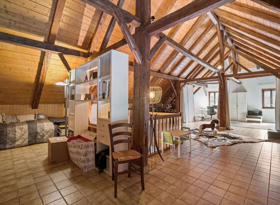 Discover this charming attic space, featuring exposed wooden beams and a vaulted ceiling that adds rustic character.