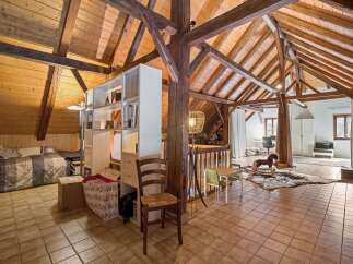 Discover this charming attic space, featuring exposed wooden beams and a vaulted ceiling that adds rustic character.