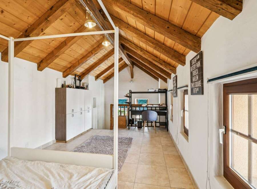 Experience rustic charm and modern comfort in this unique attic bedroom.